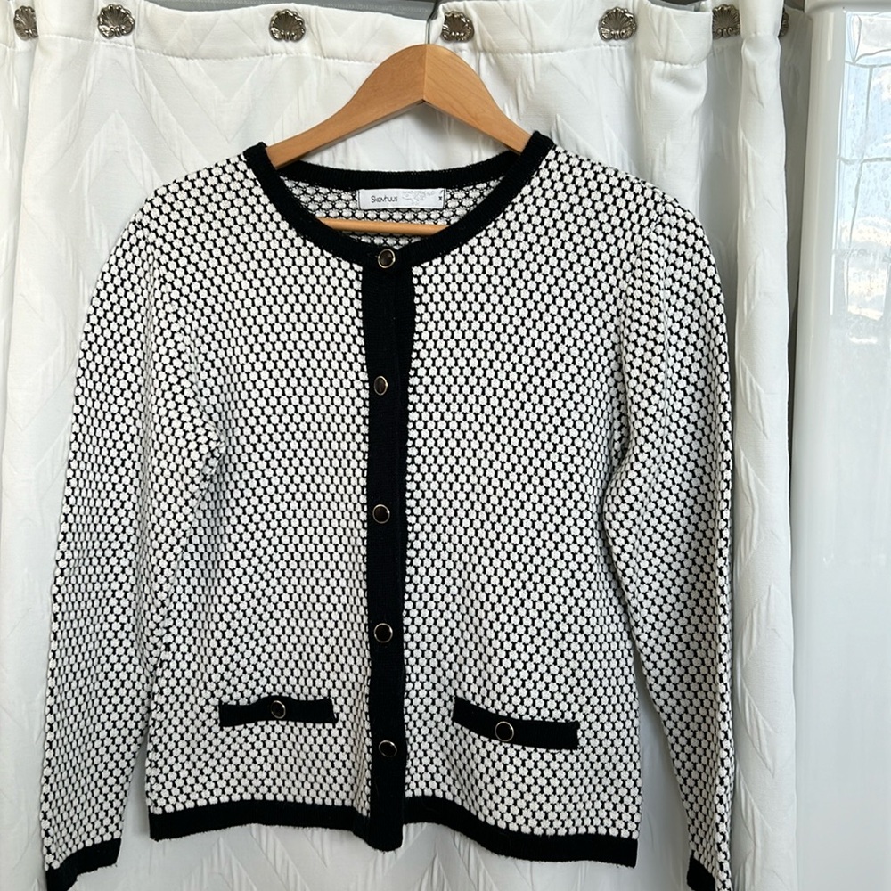 Skovhus white and black cardigan coat with black and goal buttons.